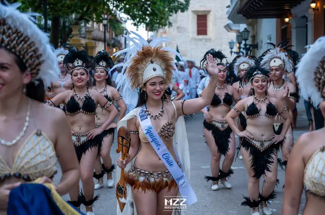Parejas de Kahuira bailando cueca con vestidos floreados en el escenario de Pica
