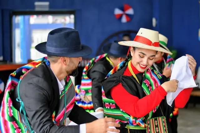 Bailarines de Kahuira con aguayos multicolores, sombreros y pañuelos blancos